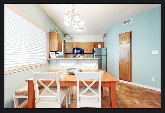 kitchen featuring tile patterned floors, kitchen peninsula, hanging light fixtures, a chandelier, and stainless steel refrigerator