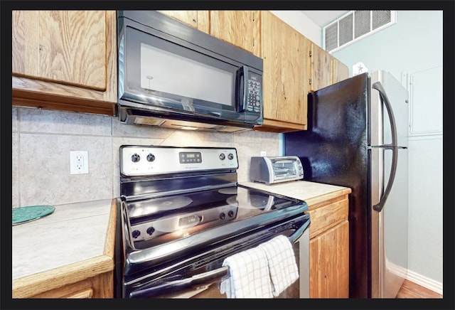 kitchen with black appliances and backsplash