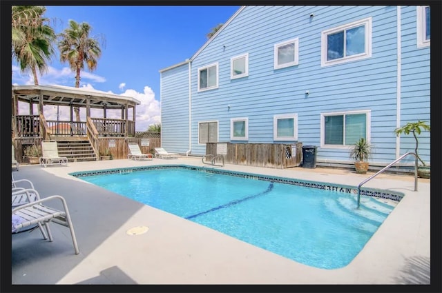 view of swimming pool with a patio area and a wooden deck