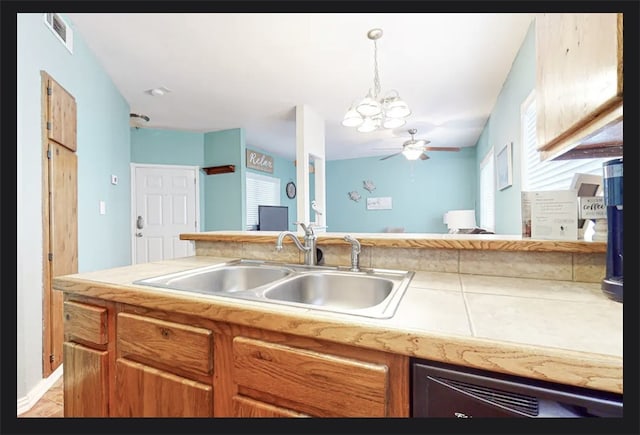 kitchen featuring ceiling fan with notable chandelier, sink, and decorative light fixtures