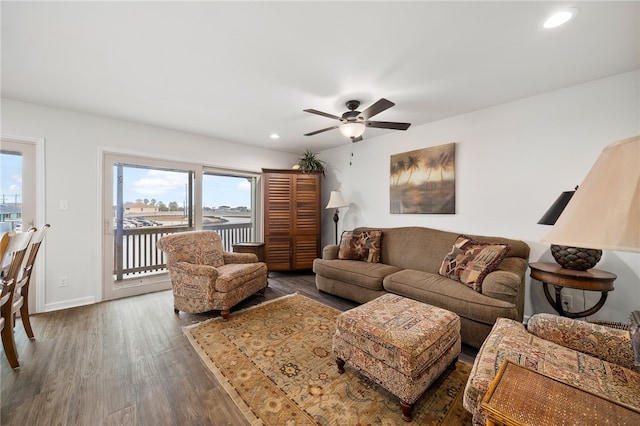 living room featuring dark wood-type flooring and ceiling fan