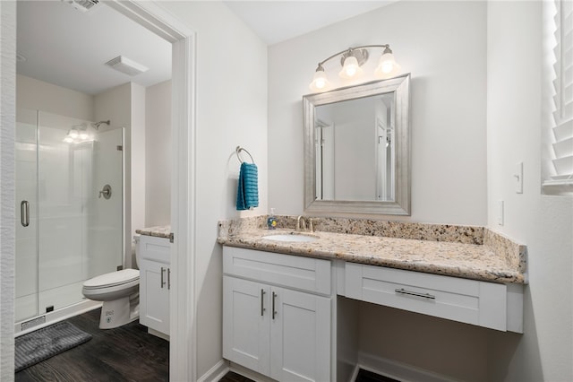 bathroom with hardwood / wood-style floors, vanity, toilet, and a shower with door