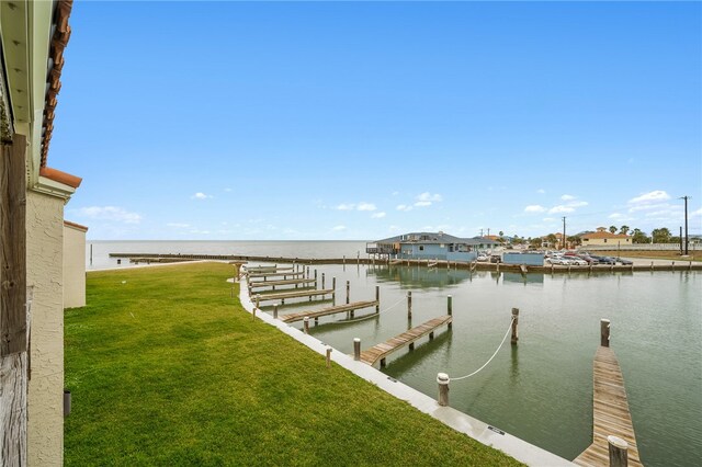 view of dock featuring a water view and a yard