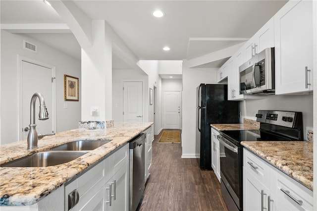 kitchen with white cabinetry, sink, appliances with stainless steel finishes, light stone countertops, and dark hardwood / wood-style flooring