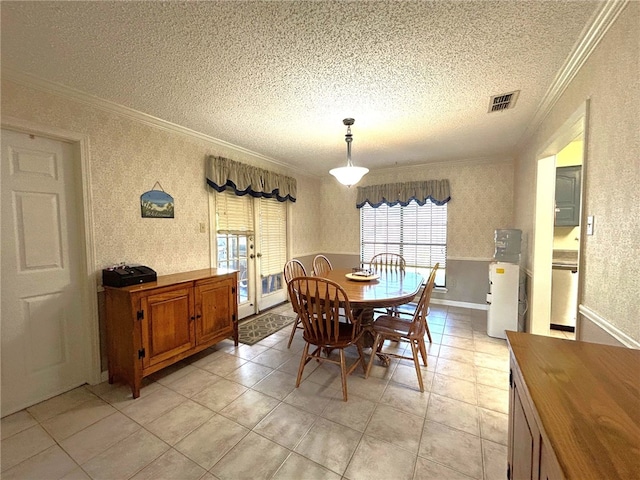 dining area featuring light tile patterned floors, a textured ceiling, and crown molding