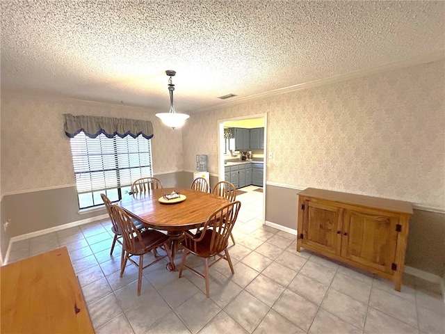 tiled dining room featuring a textured ceiling and crown molding