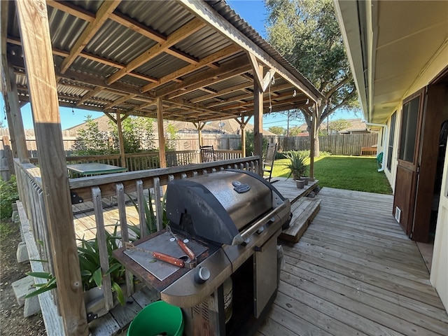 wooden terrace with a lawn and a grill