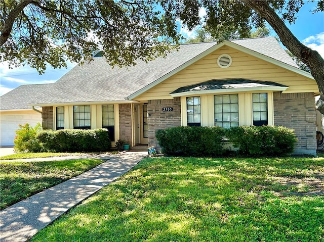 view of front of home featuring a front yard and a garage