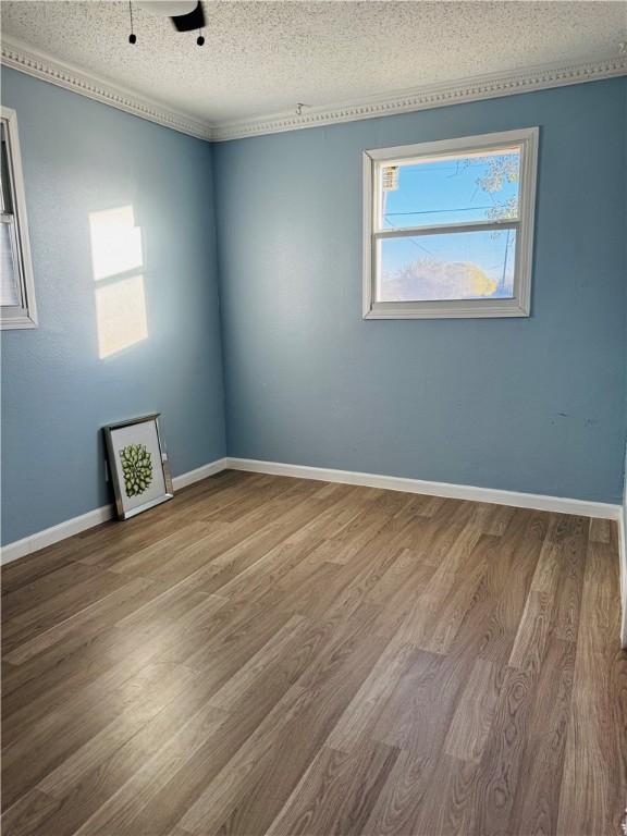 unfurnished room with hardwood / wood-style floors and a textured ceiling