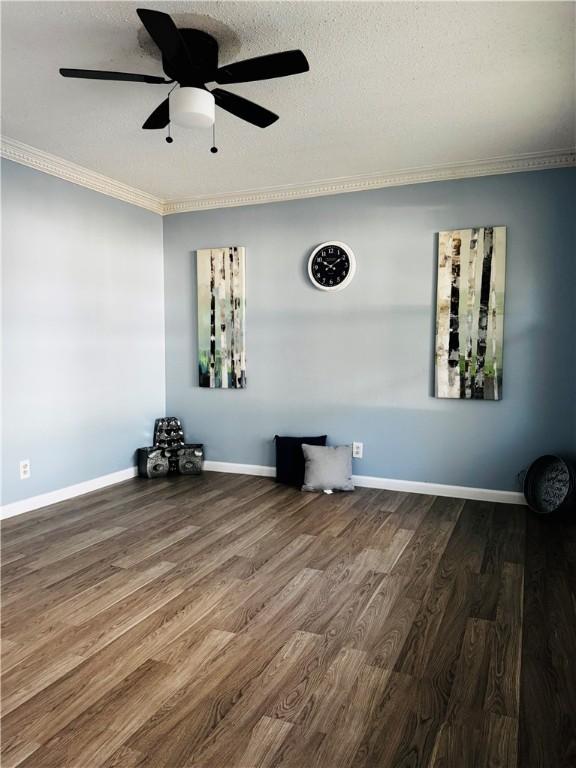 spare room featuring wood-type flooring, a textured ceiling, ceiling fan, and crown molding