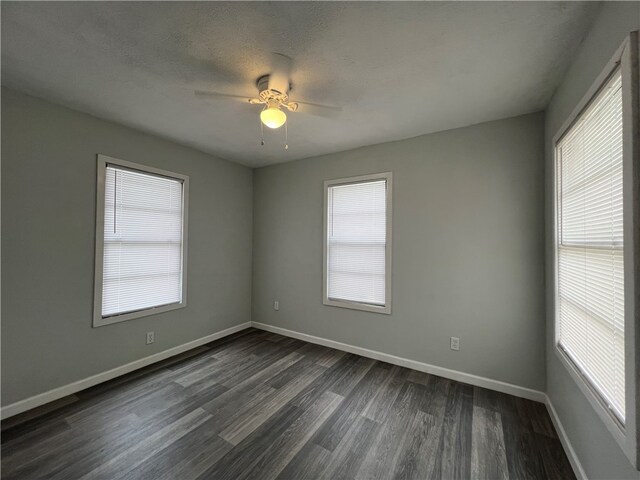 empty room featuring a textured ceiling, ceiling fan, and dark hardwood / wood-style flooring