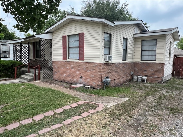 view of front of home with a front yard and cooling unit