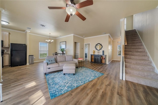 living room featuring ceiling fan with notable chandelier, wood-type flooring, and ornamental molding