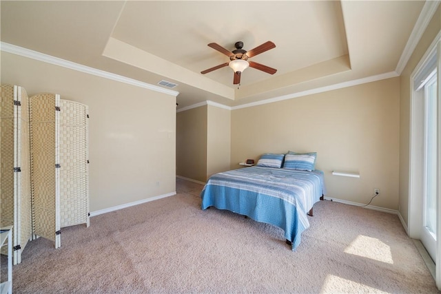 carpeted bedroom featuring a tray ceiling, ceiling fan, and crown molding