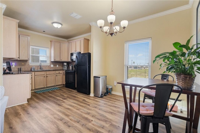 kitchen with an inviting chandelier, backsplash, crown molding, light brown cabinetry, and black appliances