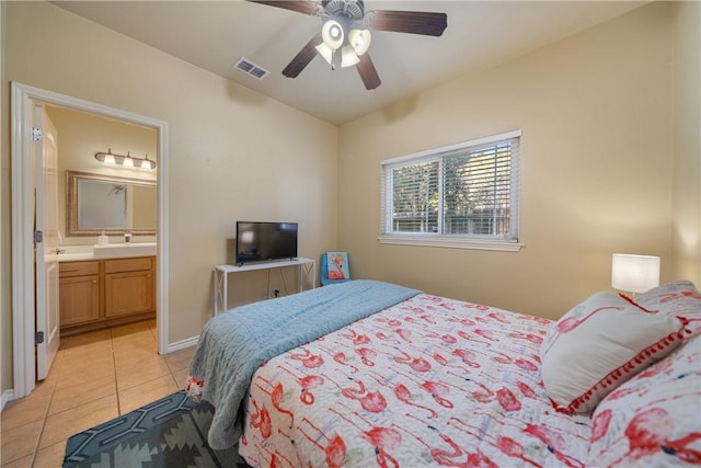 tiled bedroom with connected bathroom, ceiling fan, and sink