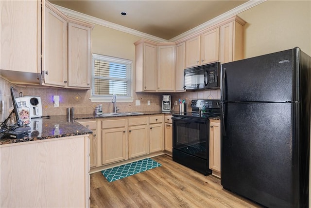 kitchen with sink, light hardwood / wood-style flooring, dark stone countertops, black appliances, and ornamental molding