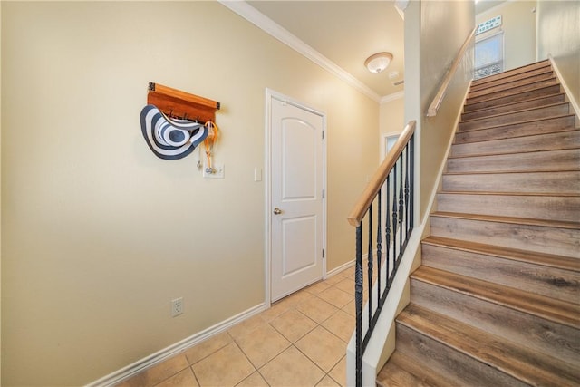 staircase featuring crown molding and tile patterned flooring