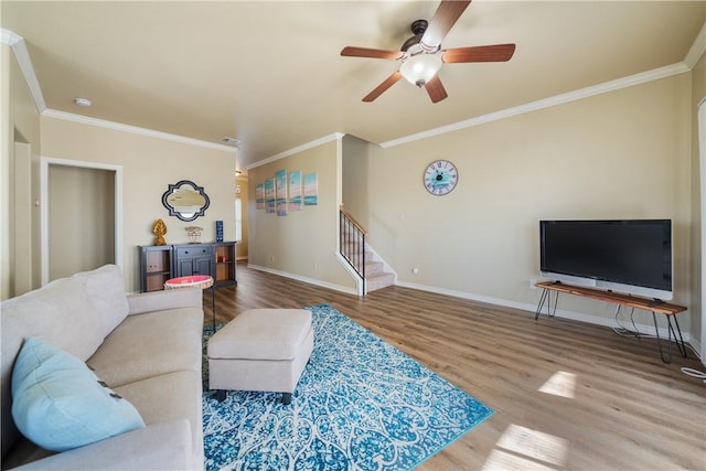 living room with hardwood / wood-style flooring, ceiling fan, and ornamental molding