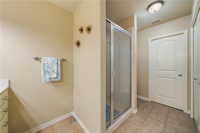 bathroom featuring tile patterned flooring, vanity, and an enclosed shower