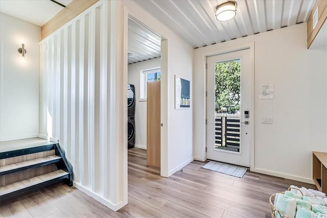 entryway featuring stacked washer / dryer and light wood-type flooring