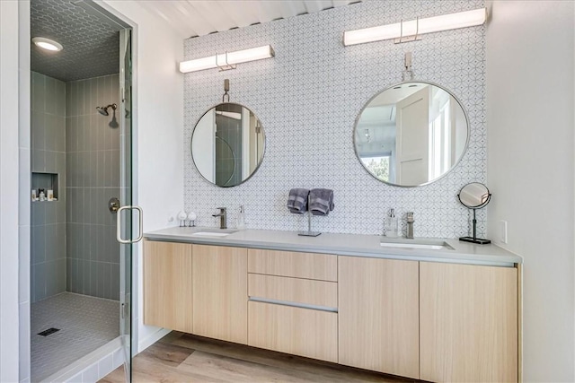 bathroom featuring vanity, backsplash, a shower with shower door, and wood-type flooring