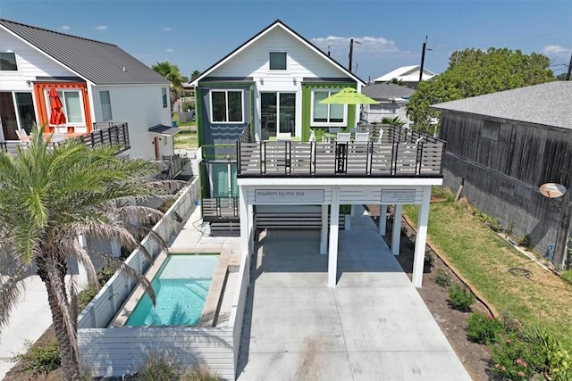 rear view of property with a balcony and a fenced in pool