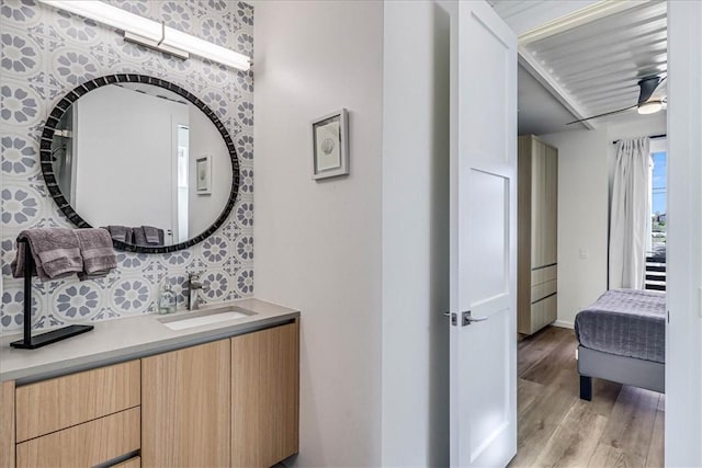 bathroom featuring vanity, decorative backsplash, wood-type flooring, and ceiling fan