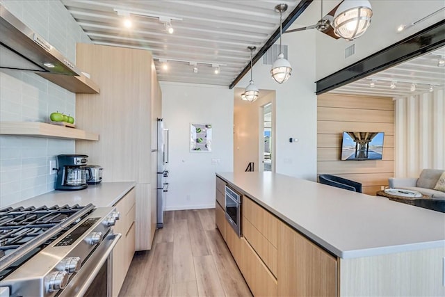 kitchen featuring tasteful backsplash, pendant lighting, stainless steel appliances, a large island, and wall chimney range hood