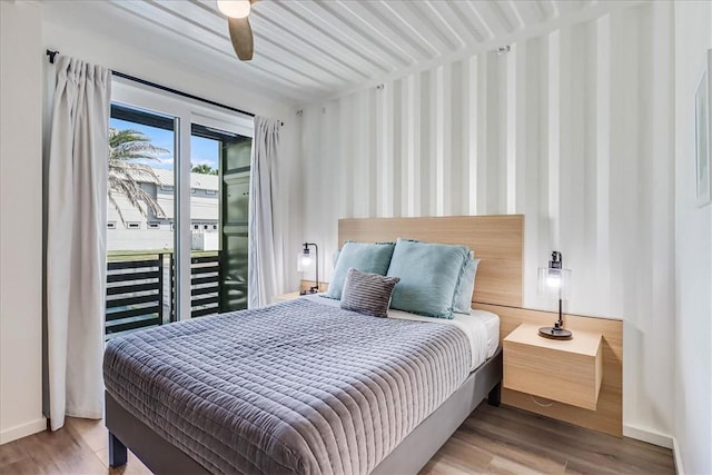 bedroom with wood-type flooring and access to exterior