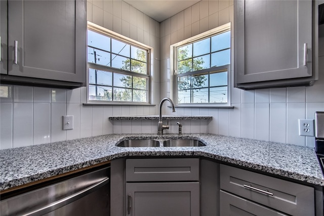 kitchen featuring gray cabinets, light stone countertops, sink, and dishwasher