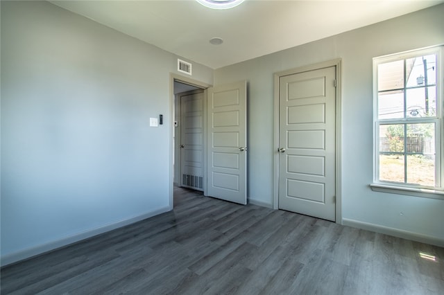 unfurnished bedroom with dark wood-type flooring