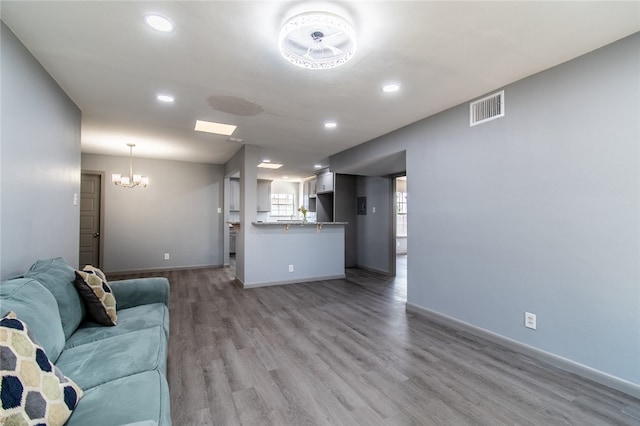 unfurnished living room with light hardwood / wood-style flooring and an inviting chandelier