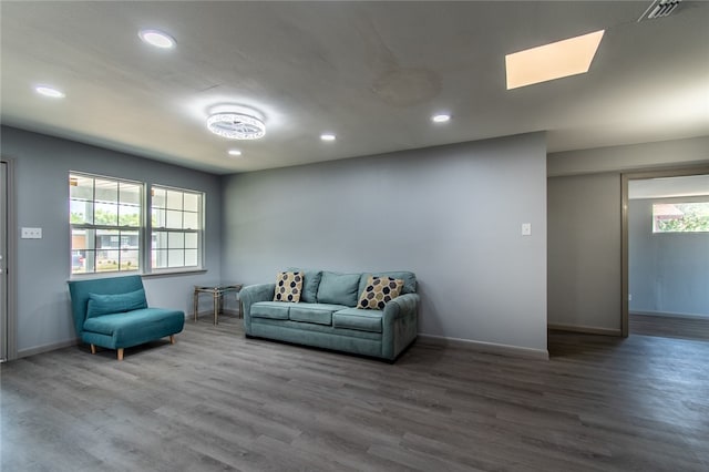 living room featuring hardwood / wood-style flooring and a skylight