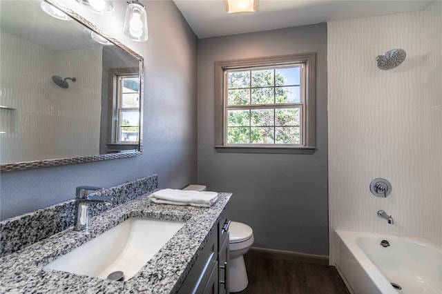 full bathroom with hardwood / wood-style floors, vanity, toilet, and tiled shower / bath