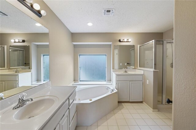 7617 Del Rio Dr, Corpus Christi, TX 78413 - bathroom with a stall shower, a textured ceiling, two vanities, tile patterned flooring, and a tub with jets