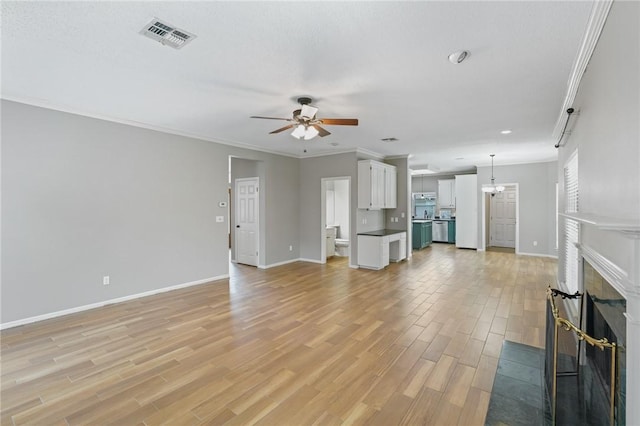 7617 Del Rio Dr, Corpus Christi, TX 78413 - unfurnished living room featuring a ceiling fan, light wood-type flooring, crown molding, a fireplace, and a chandelier