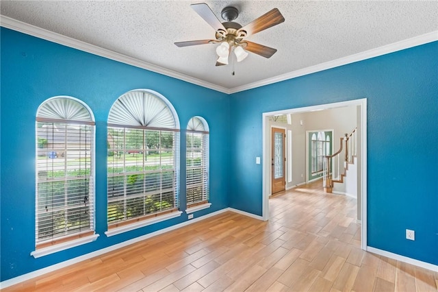 7617 Del Rio Dr, Corpus Christi, TX 78413 - empty room featuring a textured ceiling, crown molding, wood finished floors, ceiling fan, and stairs