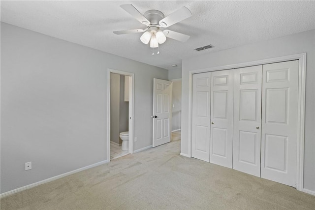 7617 Del Rio Dr, Corpus Christi, TX 78413 - unfurnished bedroom featuring carpet floors, a closet, connected bathroom, ceiling fan, and a textured ceiling