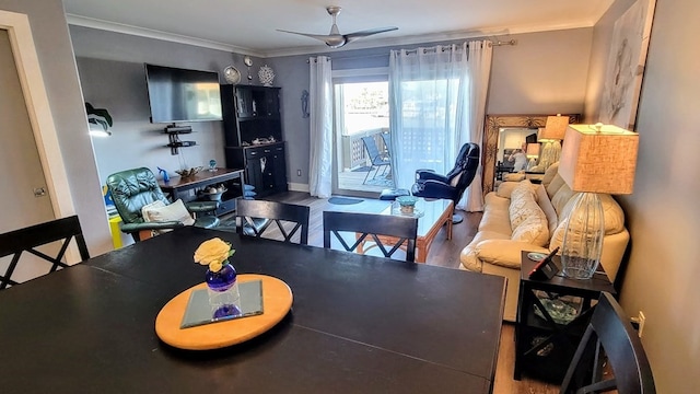 dining space with baseboards, wood finished floors, a ceiling fan, and crown molding