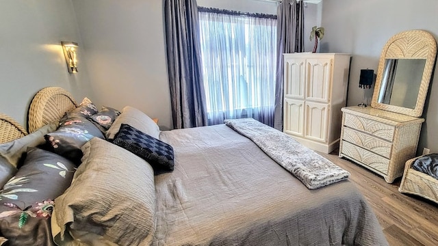 bedroom with multiple windows and wood finished floors