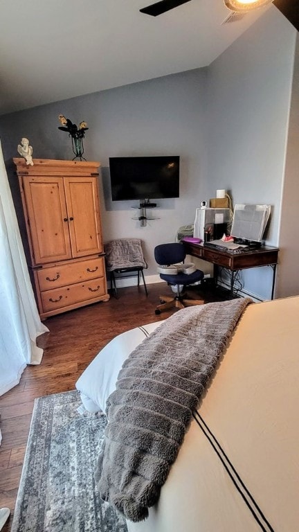 bedroom featuring dark wood-style floors, vaulted ceiling, and a ceiling fan