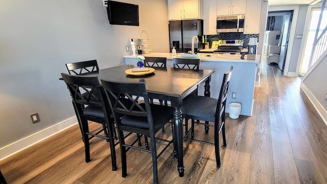 dining room with baseboards and wood finished floors