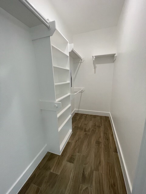 spacious closet with dark hardwood / wood-style floors