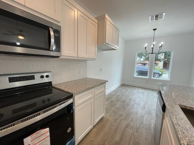 kitchen with white cabinetry, light stone countertops, and stainless steel appliances