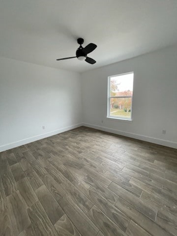 spare room with dark hardwood / wood-style floors and ceiling fan