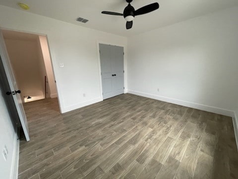 unfurnished bedroom featuring ceiling fan and dark hardwood / wood-style flooring