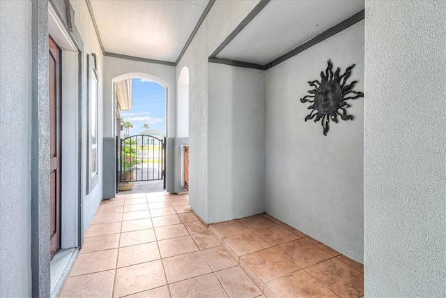 113 Bay Ct, Aransas Pass, TX 78336 - spare room with arched walkways, crown molding, a textured wall, and light tile patterned floors