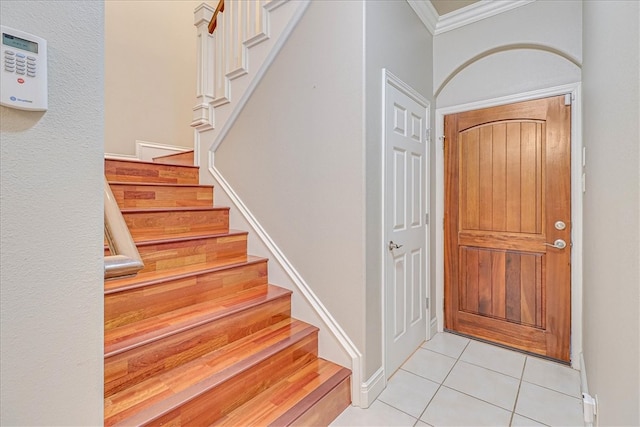 tiled foyer entrance with crown molding