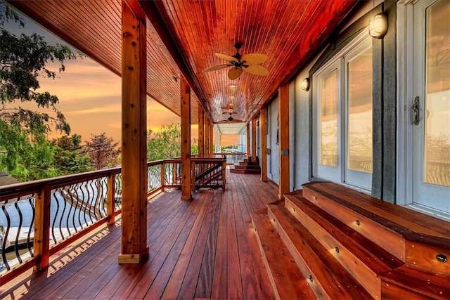 deck at dusk featuring ceiling fan